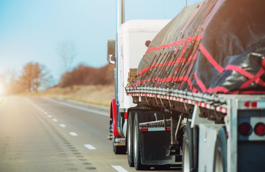 Flatbed truck hauling an oversize load with cargo securement documentation