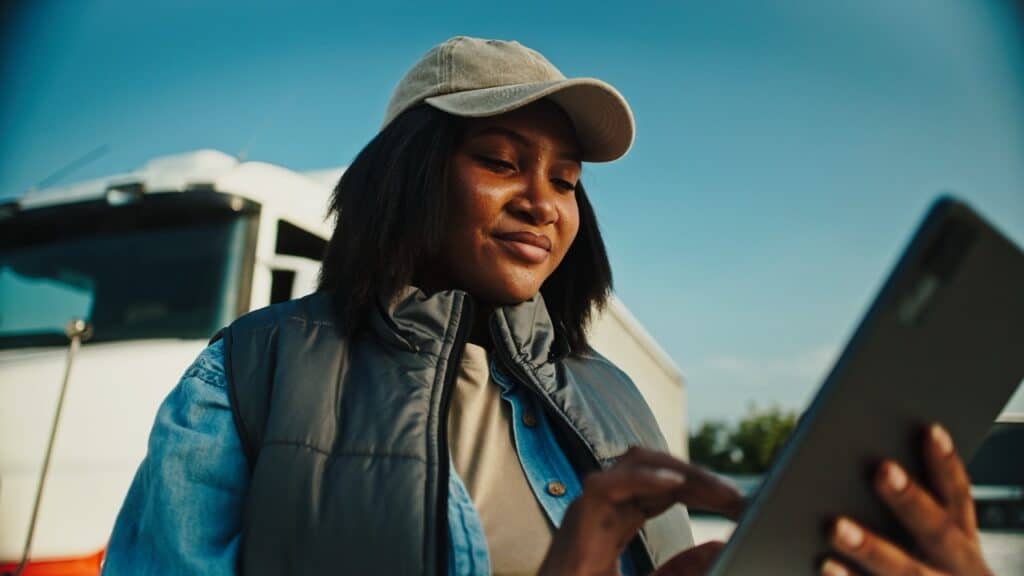Driver capturing an electronic POD signature on a tablet beside her truck